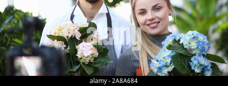 Donna e uomo Vlogger registrazione di fiore in fiore Foto Stock