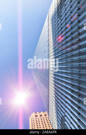 Il concetto di architettura e moderno grattacielo di vetro e acciaio esterno visto da sotto con un avveniristico star flare. Foto Stock