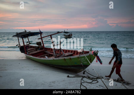 Un pescatore locale con la sua barca ormeggiata in spiaggia di Koh Rong isola, Cambogia. Foto Stock