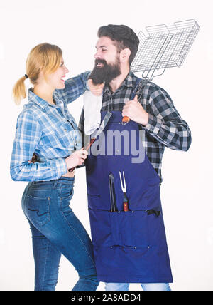 Strumenti per la tostatura di carne. Week-end in famiglia. Uomo Barbuto hipster e una ragazza. Preparazione e culinario. Matura in amore tenere gli utensili da cucina. Picnic barbecue. La cottura del cibo. Carne alla Brace alla perfezione. Foto Stock