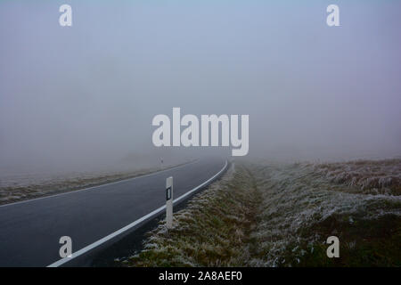 Una autostrada su una nebbia giornata invernale in Alta Rhön, Baviera, Germania con molti spazi di copia Foto Stock