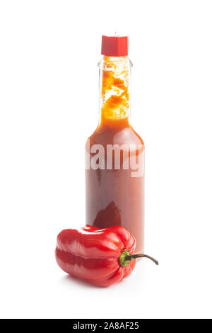 Red habanero peperoni e salsa Tabasco isolati su sfondo bianco. Foto Stock