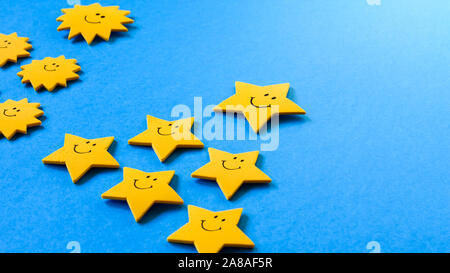 Il concetto di leadership, stelle e suns icone a forma di piramidi giacciono su uno sfondo blu Foto Stock