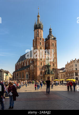 I turisti a piedi lungo la piazza principale della città vecchia di Cracovia in Polonia in una calda giornata d'autunno Foto Stock