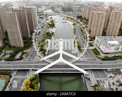 Vista aerea cityscape di Tianjin Ferris Wheel. Famoso Occhio di Tianjin ruota panoramica Ferris al di sopra del ponte Yongle e il Fiume Haihe. Apprezzato moderno punto di riferimento di Tianjin, Cina. Ottobre 28th, 2019 Foto Stock