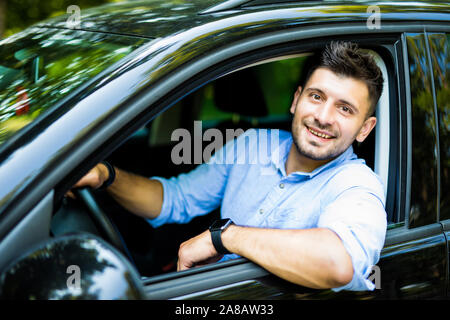 Ritratto di un bel ragazzo alla guida della sua auto Foto Stock