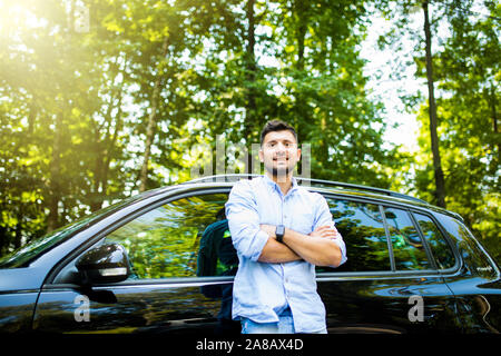 Successo giovane uomo in piedi accanto a AUTO Foto Stock