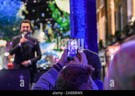 La folla pranzo Carnaby Street per vedere Ronnie Wood accendere le luci. Il tema di quest anno è di salvare il pianeta da Project Zero. Essi sono un oceano conservazione della carità e hanno creato un eco friendly display. Tutti i decori sono realizzati in materiale riciclato. Foto Stock