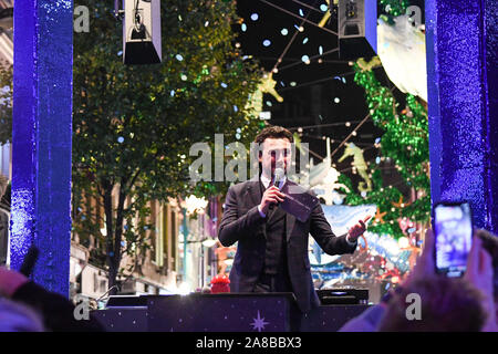 La folla pranzo Carnaby Street per vedere Ronnie Wood accendere le luci. Il tema di quest anno è di salvare il pianeta da Project Zero. Essi sono un oceano conservazione della carità e hanno creato un eco friendly display. Tutti i decori sono realizzati in materiale riciclato. Foto Stock