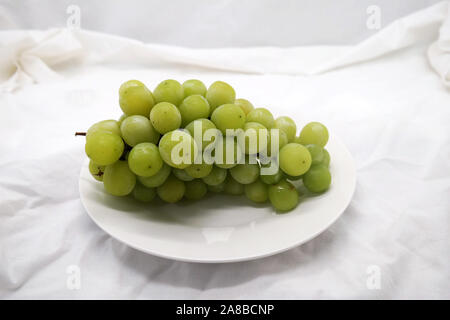 Verde brillare di uva Moscato sulla ceramica piastra rotonda Foto Stock