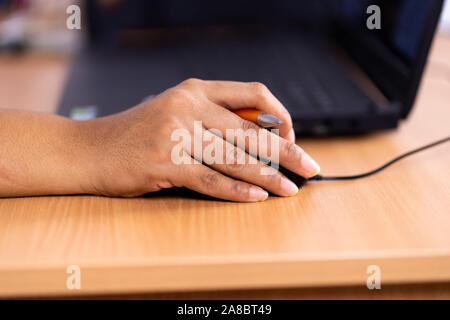 Femmina lato tenendo premuto il mouse del computer Foto Stock