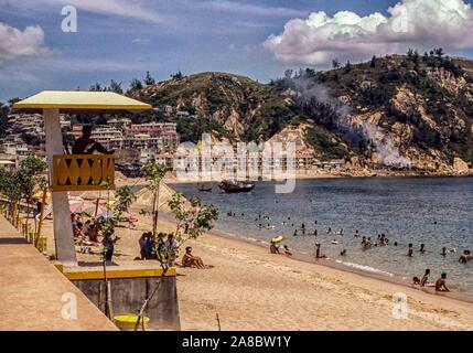 Cheung Chau Isola, Cina. 2 agosto, 1981. Un bagnino (in silhouette) orologi oltre i bagnanti a Tung Wan sulla spiaggia Cheung Chau isola. Tradizionalmente un villaggio di pescatori, l'isola, 6.2 miglia (10 km) con il traghetto da Hong Kong, è diventata una grande attrazione turistica negli ultimi anni. Credito: Arnold Drapkin/ZUMA filo/Alamy Live News Foto Stock