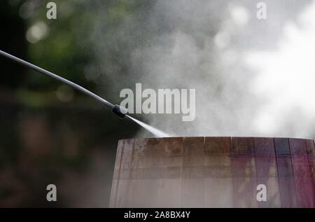 Movimento lento del Giallo bottiglia spray a gocce su sfondo nero Foto Stock