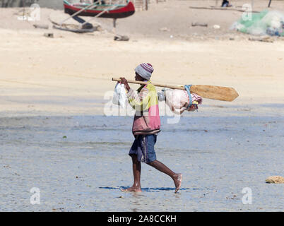 Ifaty, Madagascar il 2 agosto 2019 - pescatore di camminare sulla spiaggia con la sua marcia. Foto Stock