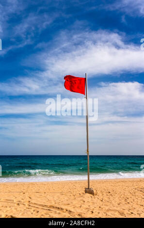 Spiaggia con bandiera rossa per avvisare del pericolo mentre la balneazione Foto Stock