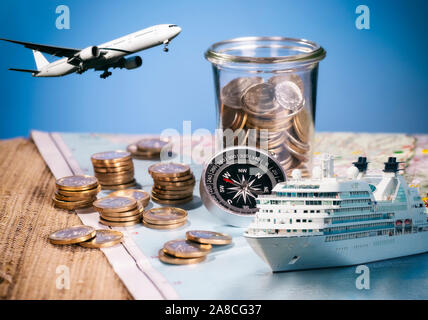Aereo e nave da crociera con bussola e monete su una mappa Foto Stock