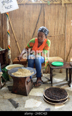 Una giovane donna etiope la tostatura i chicchi di caffè in preparazione del tradizionale caffè etiope. Foto Stock