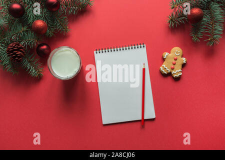 Natale vuoto vuoto lettera per Babbo Natale con un bicchiere di latte, biscotti, panpepato sul rosso. Spazio per il testo. Lay piatto. Visualizzare vfrom sopra. Foto Stock