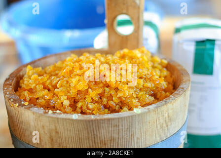 Arancia candita in ciotola di legno. Orange candy in piccola botte di legno. Ingredienti per il tradizionale Natale stollen - torta di Natale, festa tedesca dessert. Foto Stock