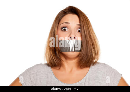 Spaventata giovane donna con nastro adesivo sopra la bocca Foto Stock