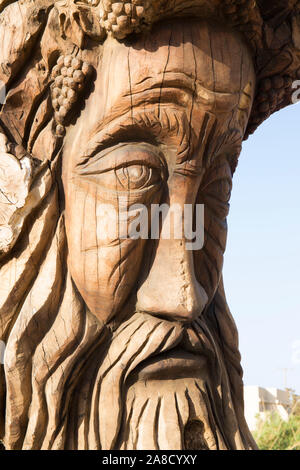 Matala, Heraklion, Creta, Grecia. Antico tronco di albero scolpito nella forma di un volto umano da artista cretese Spyros Stefanakis. Foto Stock