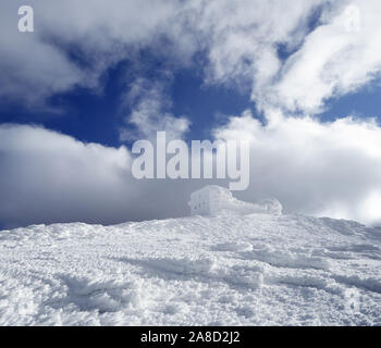 Paesaggio invernale con un osservatorio sulla cima di una montagna. Bella brina e cumuli di neve. Le difficili condizioni atmosferiche Foto Stock