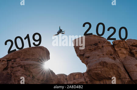 La silhouette di un uomo di saltare attraverso cliff da 2019 a 2020 Foto Stock