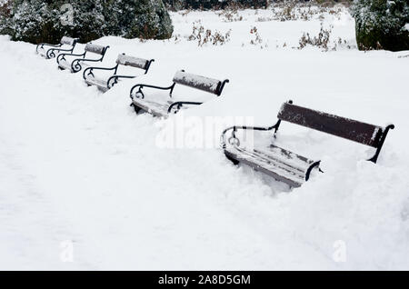 Winter Park con red panche coperte di neve durante la stagione invernale. Foto Stock