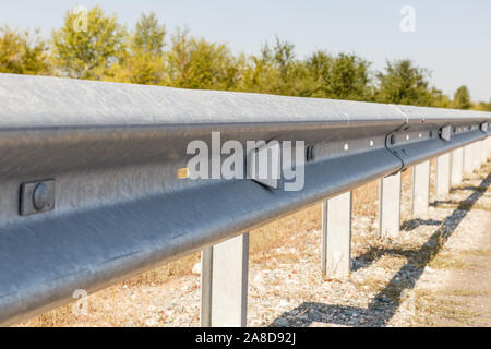 Strada bianca riflettori lungo la strada. metallo scherma su strada di tipo barriera di close-up. Su strada e la sicurezza del traffico Foto Stock