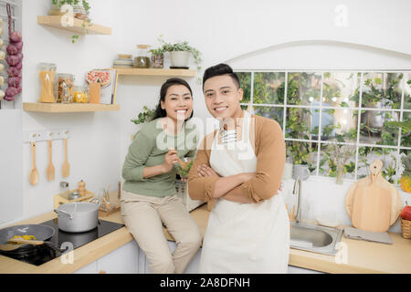 Felice coppia giovane mangiare e parlare in cucina Foto Stock