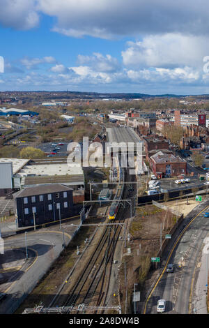 Arial vista di un treno in partenza Stoke on Trent station nel cuore delle Midlands, pendolari che viaggiano da e verso le loro destinazioni, pubblici trans Foto Stock