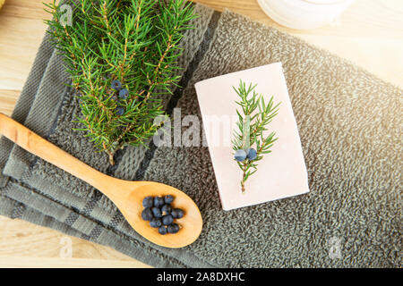 Appartamento vista laici latino di ginepro Juniperus communis berry saponetta, ginepro ramo di albero con confier coni e cucchiaio con frutti di bosco, copia dello spazio. Tre di ginepro Foto Stock