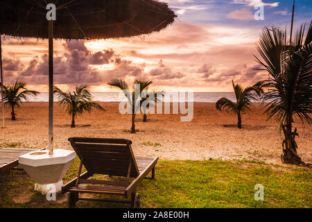 Tramonto sulla spiaggia privata di un lussuoso complesso vacanze in Gambia, in Africa occidentale. Foto Stock