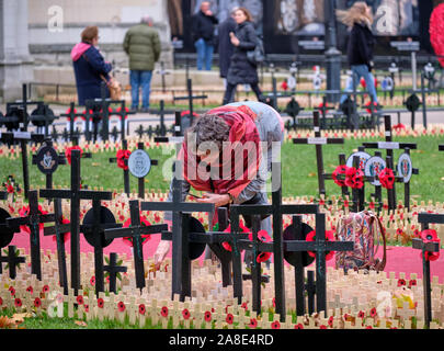 Westminster, Londra, Regno Unito. 8 novembre 2019. Persone provenienti per rendere omaggio ai soldati caduti al campo del ricordo Westminster Abbey motivi, ora aperto al pubblico in generale. Donna aggiungendo una croce in un insieme di lotti. Il campo resterà aperto fino al XVIII di novembre. Credito: JF Pelletier / Alamy Live News Foto Stock