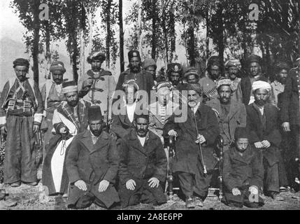 'Shaykh Hamid Pasha', c1906-1913, (1915). Ritratto di gruppo di un sheikh e il suo corteo, in un villaggio '...che si trova forse due miglia e mezzo fuori Bashkala..." (Baskale, nel sud-est della Turchia?). Alcuni tra gli uomini indossano cinturoni riempito di proiettili. Da "i califfi nell' ultimo patrimonio, una breve storia dell'Impero Turco" dal tenente-colonnello Sir Mark Sykes. [Macmillan &AMP; Co, London, 1915] Foto Stock