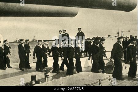 "Il Re della visita al Grand flotta', la prima guerra mondiale, giugno 1917 (c1920). '...Bluejackets [marinai della Royal Navy] marching passato sua maestà [King George V] a bordo di una delle corazzate" presso la Scapa fluire della costa nord della Scozia. George's figlio Principe Albert (più tardi re George VI), era in servizio a bordo di HMS 'Malaya' al momento. Da "La Grande Guerra Mondiale: una storia", Volume VII, edito da Frank un Mumby. [Il Gresham Publishing Company Ltd, Londra, c1920] Foto Stock