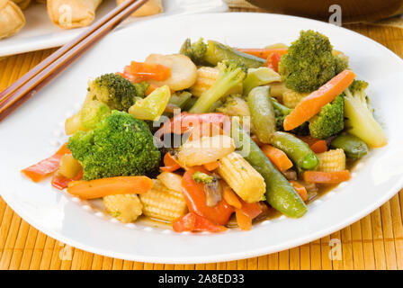 Vegetariano stir fry fatta con broccoli, zucchero snap piselli, carote, acqua di castagne, peperoni rossi, baby pannocchia di mais, e funghi in un pizzichino di sesamo allo zenzero Foto Stock