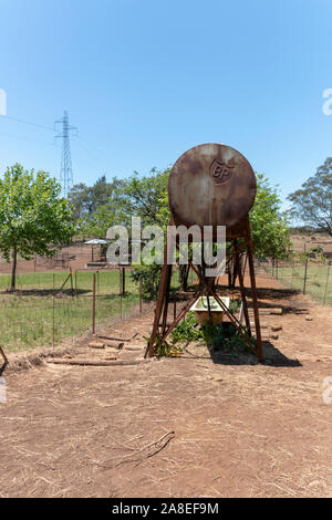 Africa Durban-South, Novembre 2019- Una vista ravvicinata di un vecchio arrugginito metallo BP Water Tower in un campo aperto in una calda giornata d'estate in fattoria Foto Stock