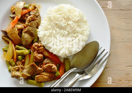 Mescolare il pollo fritto misto e interiora con peperoncino dolce mangiare giovane con il riso sul piatto Foto Stock