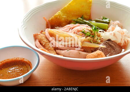 Vermicelli di riso con i gamberi a sfera e croccante di calamari nella zuppa rossa Foto Stock