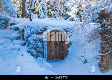 Blue Panorama invernale della coperta di neve forest, segreto vecchia porta di legno sul versante di una montagna Foto Stock