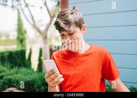 Profilo di un felice guy scrivere messaggi su un telefono intelligente Foto Stock