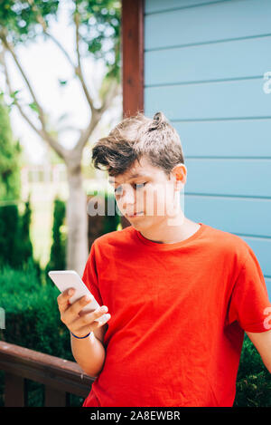 Profilo di un felice guy scrivere messaggi su un telefono intelligente Foto Stock