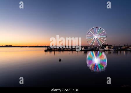 Illuminata ruota panoramica Ferris a livello nazionale porto vicino la capitale della nazione di Washington DC al tramonto Foto Stock