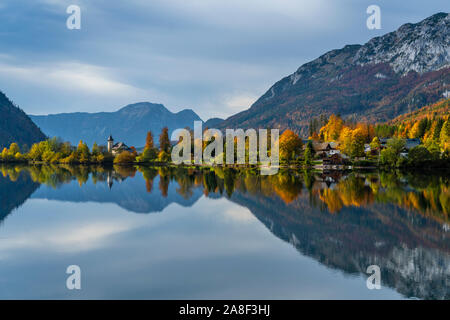 Caduta delle Foglie colore in alberi e il lago calmo con riflessioni a Grundlsee, Austria, l'Europa. Foto Stock