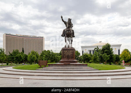 Statua di Amir Temur a cavallo illustrato tra l'Uzbekistan Hotel e il National Congress Center a Piazza Indipendenza, Tashkent Foto Stock