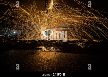 La masterizzazione di lana di acciaio la filatura. Docce di incandescente di scintille di filatura della lana di acciaio Foto Stock