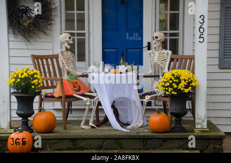 Due scheletri seduti ad un tavolo per la cena con un pasto romantico con il vino per la festa di Halloween data la notte, Yarmouth, Maine, Stati Uniti d'America Foto Stock