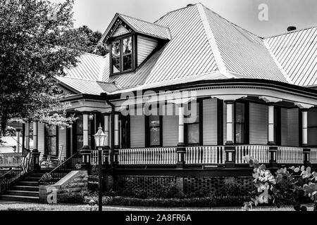 Un'impressionante residenza in stile Queen Anne con veranda avvolgente e tetto a timpani nel quartiere storico di Hattiesburg, MS, USA, B&W. Foto Stock