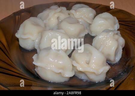 In casa gnocchi di carne. Cucinato al momento fagottini ripieni di carne su un piatto di close-up. Foto Stock